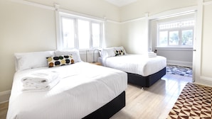 A hotel room with two beds, white bedding, a patterned rug, and large windows. - Stylish Bondi Beach pad moments from sand & surf (Bondi Beach)