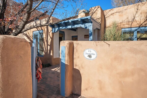 A traditional adobe building with a blue door and a sign indicating "26 Dreamcatcher". - Walk Everywhere, Kiva Fireplace (Santa Fe)