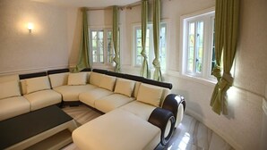 A modern living room with a sectional sofa, a coffee table, and a fireplace. - The Best 2 Bedrooms Townhouse in Montego Bay! (Montego Bay)