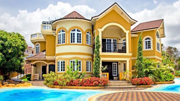 A large, two-story building with a curved swimming pool in front. - The Best 2 Bedrooms Townhouse in Montego Bay! (Montego Bay)