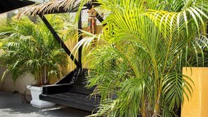 A tropical garden with potted plants and a black metal structure. - The Best 2 Bedrooms Townhouse in Montego Bay! (Montego Bay)