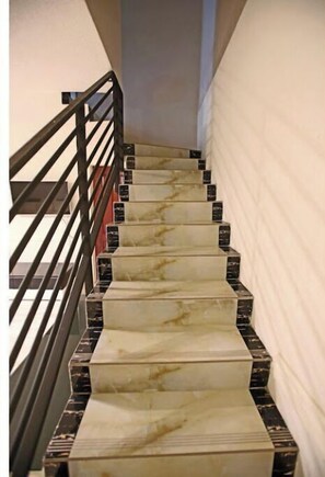 Stairs lead upwards, flanked by handrails and a wall.