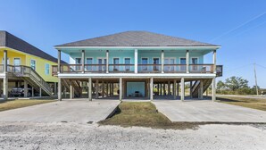Une maison à deux étages avec un balcon, une véranda et une allée.