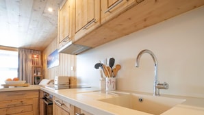 Une cuisine moderne avec des meubles en bois, un plan de travail blanc et un évier en acier inoxydable.