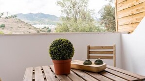 A wooden table with a potted plant and sunglasses on it, overlooking a scenic view. - APARTMENT MONKÓ GOLF & BEACH (Benalmadena)