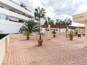 A courtyard with tiled flooring, palm trees, and a building labeled "LOS ALAMOS".