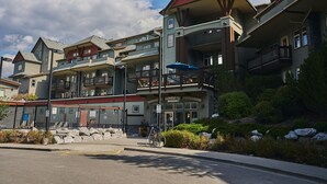 Een meerhoog hotel met balkons, een overdekt terras en een gevel van natuursteen.