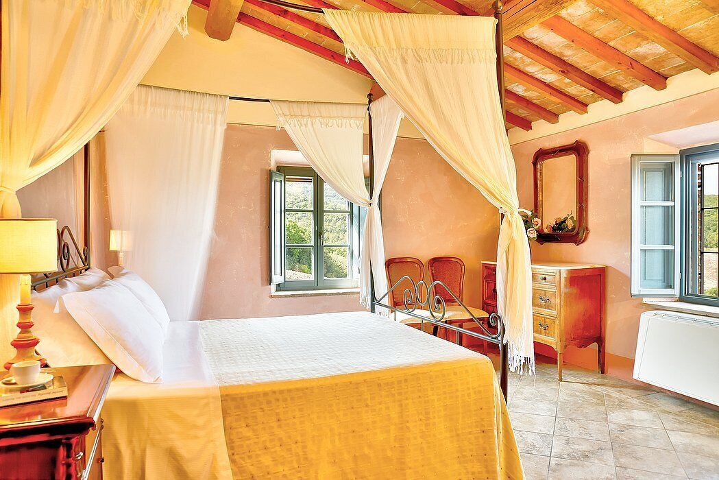 Un dormitorio con cama, mesita de noche, cómoda y ventana.