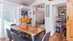 A dining area with a wooden table and chairs, a vase with flowers, and a 'WELCOME' sign on the wall. - charming 2-bedroom pioneer home near brian head ski resort and national parks in parowan, utah (Parowan)