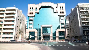 A hotel with a prominent blue facade, multiple balconies, and a central entrance. - WESCOTT PEARL HOTEL APARTMENTS (Dubai)