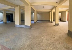 Expansive interior with high ceilings and columns, featuring a unique floor design.