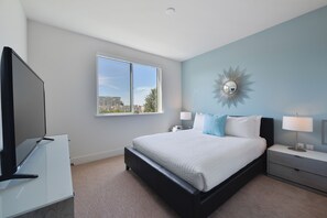 A bedroom with a large bed, a TV, a window, and a city view.
