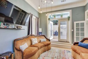 A living room with a sofa, a television, and a sliding glass door to the outside.