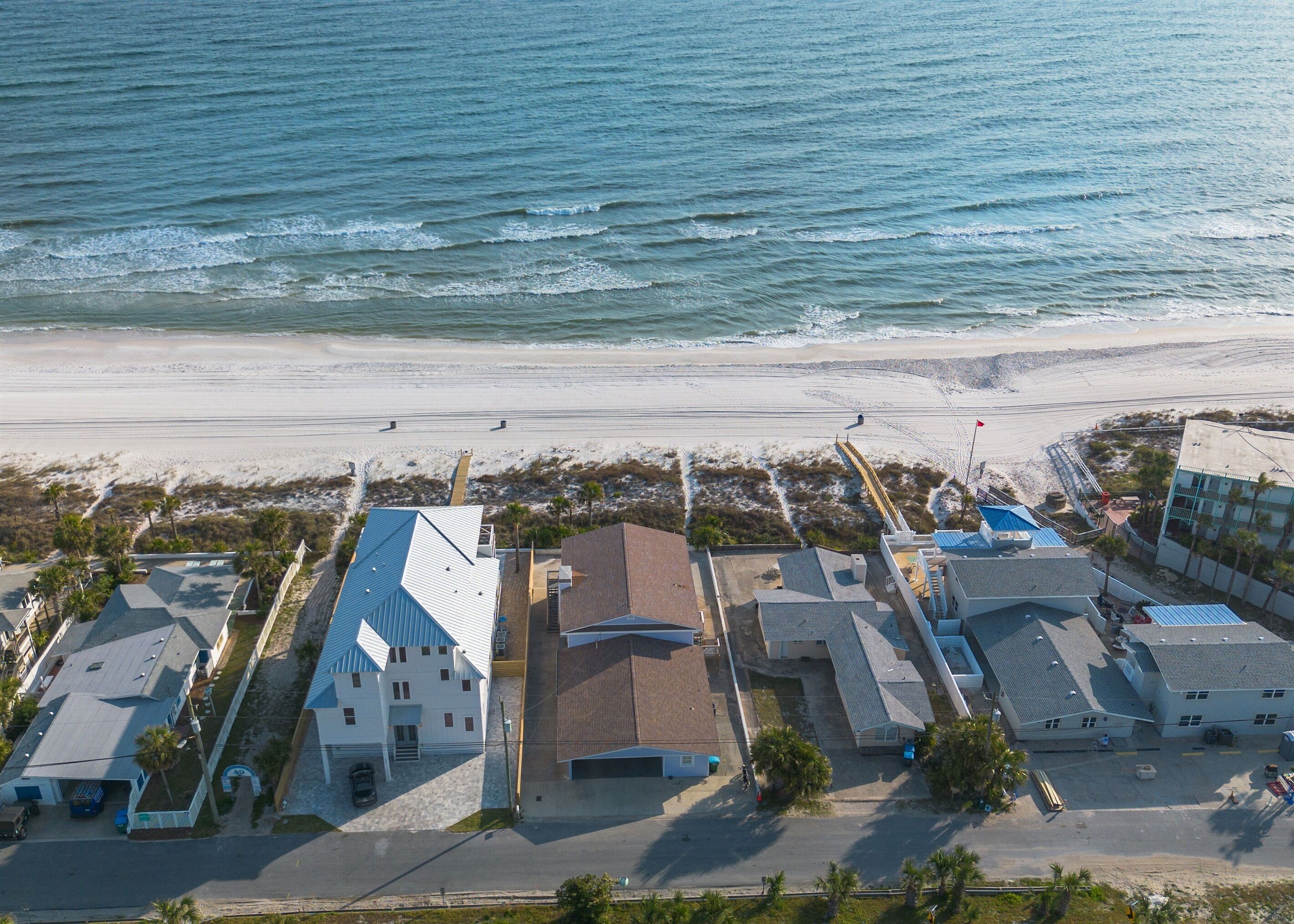 An aerial view of a coastal area with buildings, a beach, and the ocean.