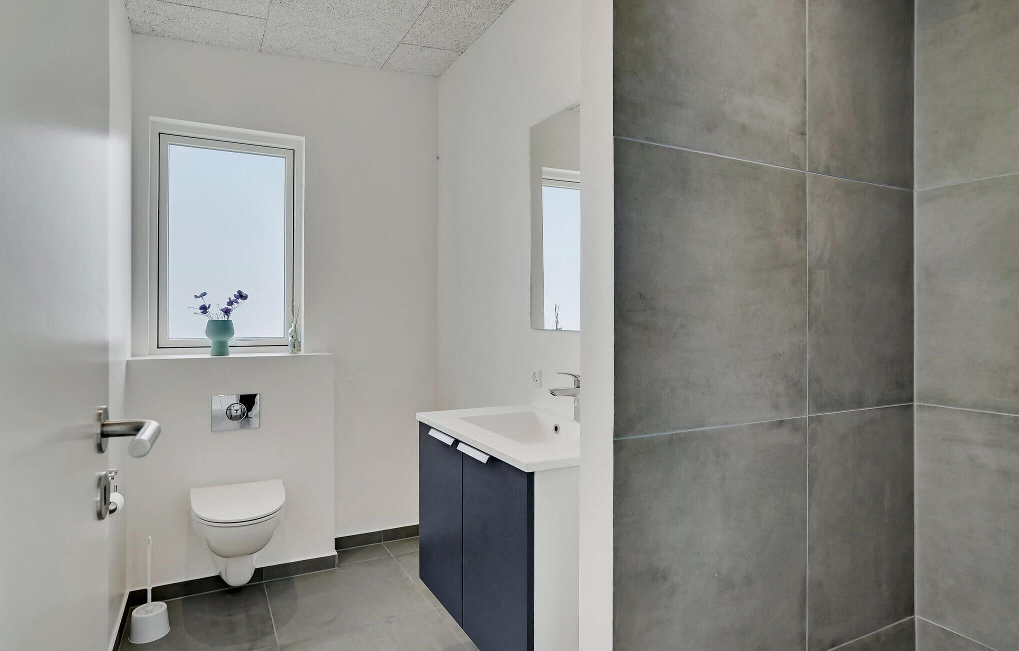 Une salle de bain moderne avec des toilettes, un lavabo et une fenêtre.