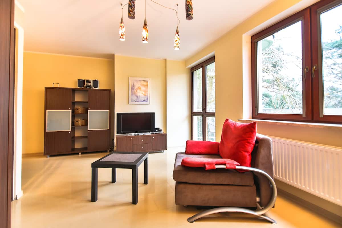 Ein Wohnzimmer mit einer Couch, einem Couchtisch, einem Fernseher und einem Schrank.