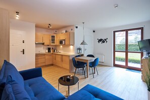 A modern apartment with a living room, kitchen, and dining area.
