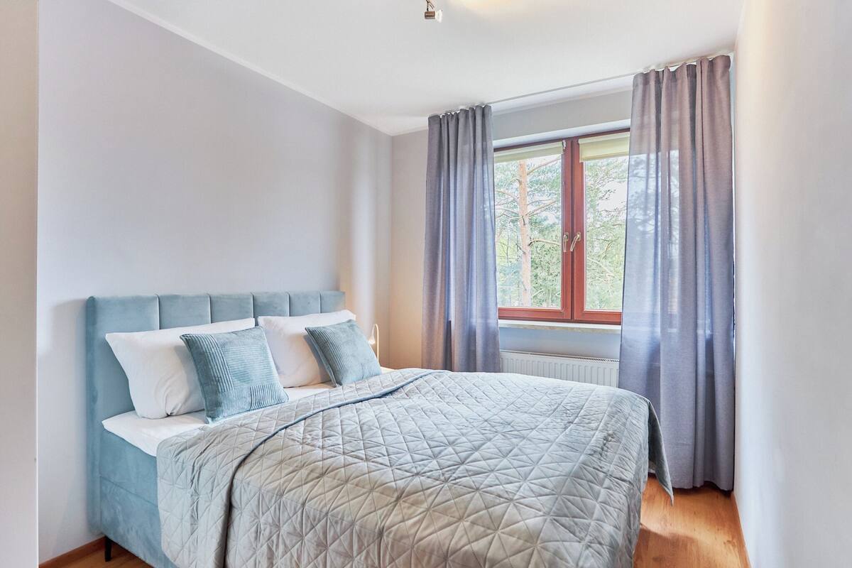 Ein Schlafzimmer mit Bett, Vorhängen und einem Fenster.
