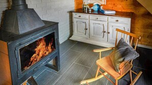A room with a wood-burning stove, a wooden chair with a cushion, and a white cabinet. - 2 bedroom amazing apartment in Bobolin (Bobolin)