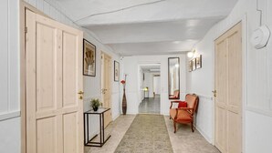A hallway with wooden doors, a mirror, a chair, and a small table with a plant. - 1 bedroom nice apartment in Esbjerg V (Esbjerg V)