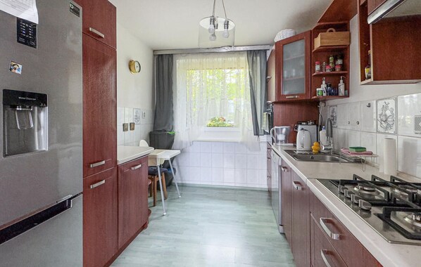 A compact kitchen with a refrigerator, stove, and water dispenser.