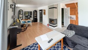 Una sala de estar moderna con chimenea, un sofá, una mesa de centro y un televisor.