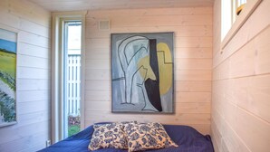 A bedroom with a bed, a painting, and a wall-mounted abstract art piece. - Lovely home in Skivarp with WiFi (Skivarp)