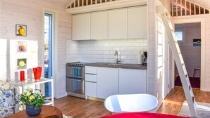 A compact kitchen with white cabinets, a stainless steel stove, and a sink. - Lovely home in Skivarp with WiFi (Skivarp)
