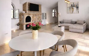 Una sala moderna con chimenea, una mesa redonda de comedor y un sofá.