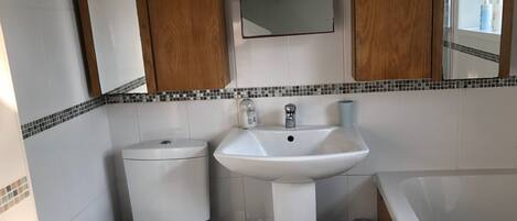 A bathroom with a toilet, sink, and bathtub.