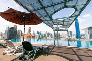 Utomhuspool, parasoller och solstolar