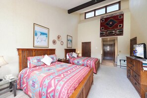 A bedroom with two beds, a television, and a dresser. - Earth and Sky Retreat | AC, Pool, Hot Tub, Golf & Ski (Durango)