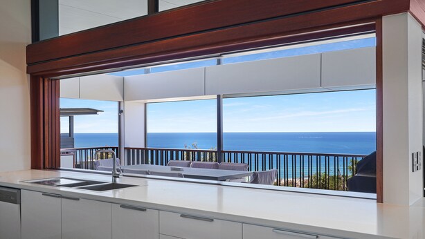 A modern kitchen with a large window overlooking the ocean. - Banyandah - Luxury Architect Designed Straddie Beachhouse (Point Lookout)