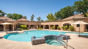 A swimming pool with a hot tub, surrounded by covered seating areas and palm trees. - Signature Complex - Highly Desirable 2/2 with Heated Pool, Spa, Steam, Sauna (Scottsdale)