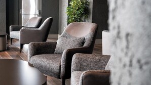 Ein stilvoller Lounge-Bereich mit gepolsterten Sesseln und einem runden Tisch.