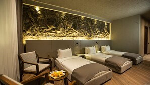 A hotel room with two single beds, a wooden chair, a small table with breakfast, and a wall-mounted aquarium. - The Erzurum Hotel (Erzurum)