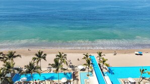 A resort with a pool, beach, and ocean view. - Beachfront Luxury Condo, Great Location! (Puerto Vallarta)