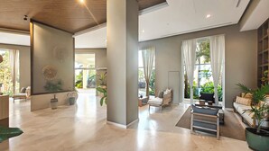 A spacious lobby with a marble floor, a wooden ceiling, and large windows with curtains. - Beachfront Luxury Condo, Great Location! (Puerto Vallarta)