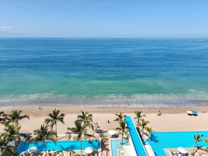 A resort with a pool, beach, and ocean view.