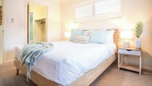 A bedroom with a bed, bedside table, lamp, and a mirror. - Saltair Kings Beach Apartment - Walk to Beach (Kings Beach)