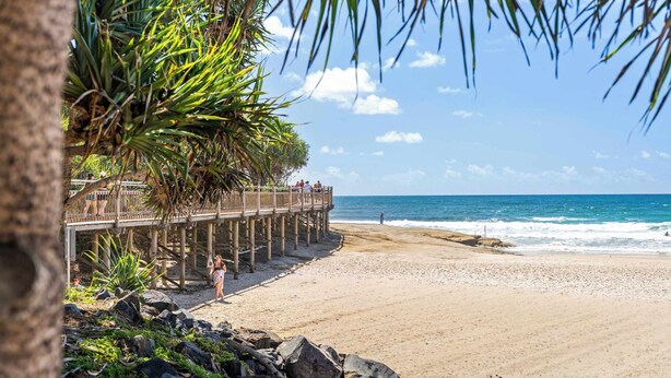 A beach with a wooden pier, rocky shoreline, and palm trees. - Saltair Kings Beach Apartment - Walk to Beach (Kings Beach)