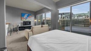 Une chambre d’hôtel avec un grand lit, une télévision, un canapé, un bureau et un balcon avec vue.