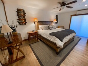A bedroom with a wooden bed, two bedside lamps, a ceiling fan, and a large window. - 1BDR Ski-In/Out Condo; Stunning Mountain Location! (Park City)