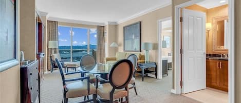 Una habitación de hotel con comedor, sala de estar con vistas y cocina.
