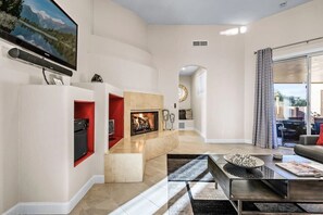 Televisión, chimenea, reproductor de DVD y libros 