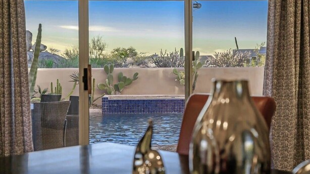 Une chambre avec vue sur une piscine et un paysage désertique.