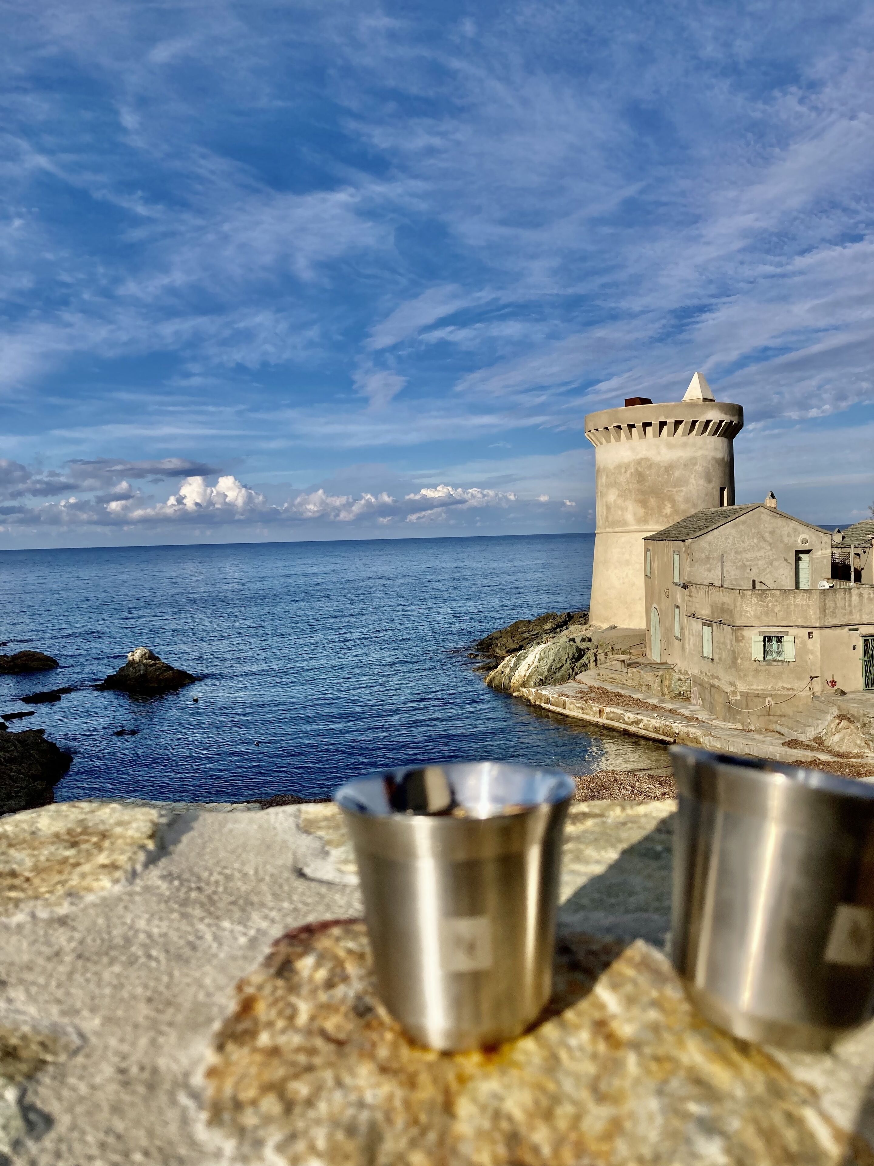 Une vue côtière avec une tour et des bâtiments situés près de la mer.