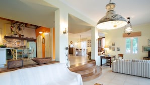 A spacious living area with a sofa, a dining table, and a kitchen in the background. - Boutique Villa Andronice with amazing view at the Ionian Sea (Tsoukalades)
