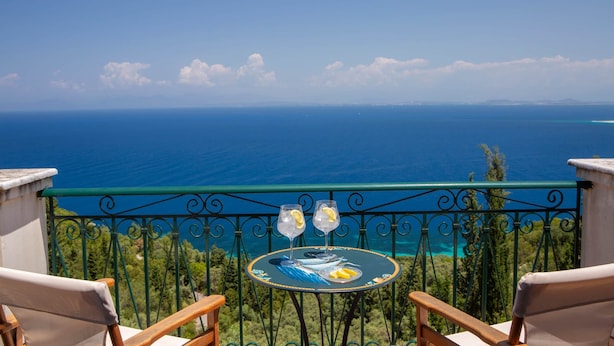 A balcony with a table and two chairs overlooking a coastal view. - Boutique Villa Andronice with amazing view at the Ionian Sea (Tsoukalades)