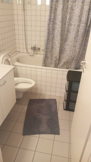 Un baño pequeño con inodoro, bañera y ducha.